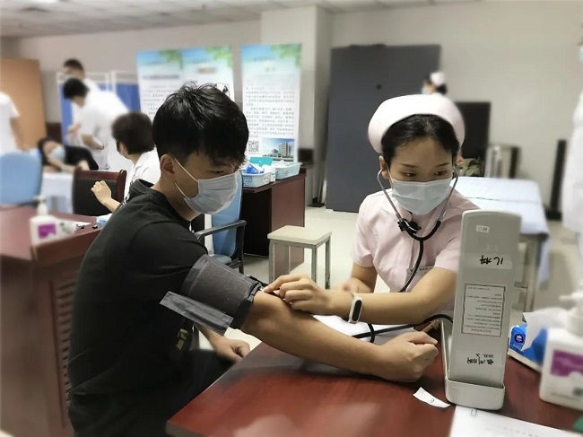 图为护理人员为刑侦支队队员测量血压
